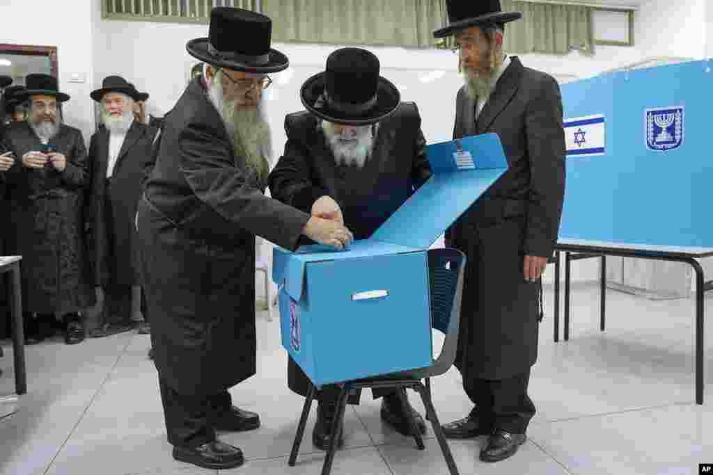Ultra-Orthodox Jews watch as their Rabbi Israel Hager votes during Israel elections in Bnei Brak. Israel is holding its fifth election in less than four years.