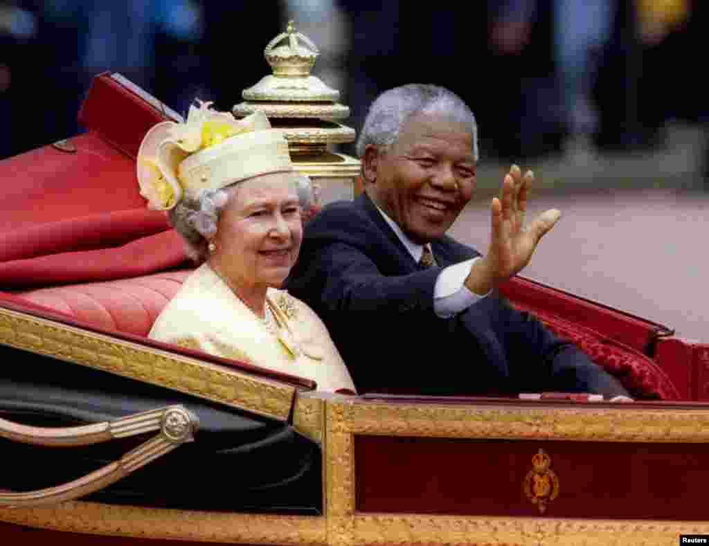 Tổng thống Nam Phi Nelson Mandela ngồi cùng Nữ hoàng Anh Elizabeth II trong xe ngựa tới Điện Buckingham ăn trưa vào ngày đầu tiên của chuyến thăm cấp nhà nước của ông ở Anh, ngày 9 tháng 7 năm 1996. 