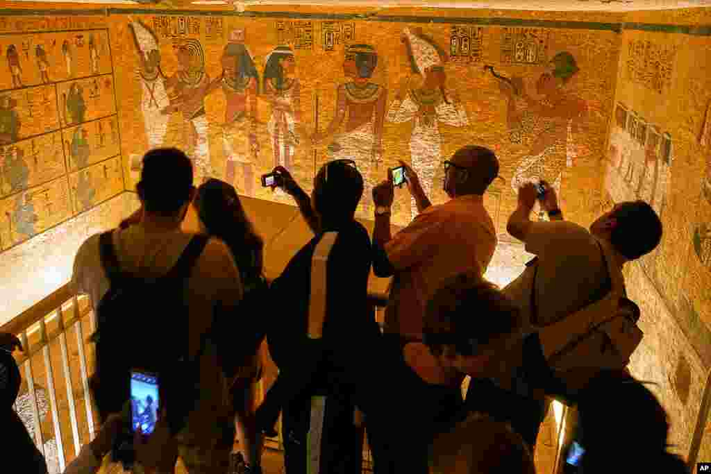 Tourists film inside the tomb of King Tutankhamun in the Valley of the Kings in Luxor, Egypt. Egypt celebrates the 100-year anniversary of the discovery of Tutankhamun's tomb by British archaeologist Howard Carter and his team.