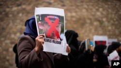 A woman holds a photograph of far-right activist Rasmus Paludan during a protest outside the Swedish consulate in Istanbul on Jan. 28, 2023. Paludan infuriated Turkey by staging a Quran-burning protest in Sweden on Jan. 21. Last week, he replicated the stunt in Copenhagen.