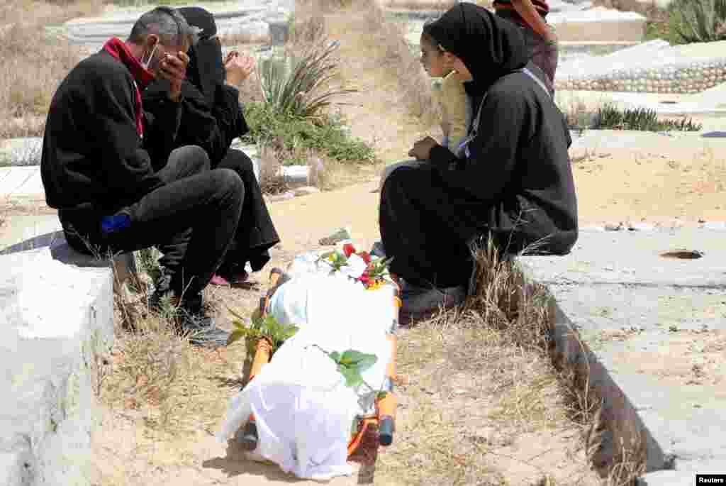 Mourners react as people rebury the bodies of Palestinians killed during Israel's military offensive and buried earlier at Nasser hospital, after bodies were moved to a cemetery in Khan Younis in the southern Gaza Strip.