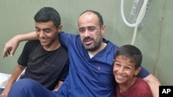 Mohammed Abu Selmia, mkurugenzi wa hospitali kuu Gaza, aliyekuwa anashikiliwa na majeshi ya Israeli akiwa na watoto wake baada ya kuachiliwa huru, pamoja na wafungwa wengine, katika Hospitali ya Khan Younis, Ukanda wa Gaza, Julai 1, 2024. 