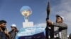 A Houthi follower holds a rocket launcher as others carry a cutout banner portraying the Galaxy Leader cargo ship that was seized by the Houthis, during a parade as part of a "popular army" mobilization campaign in Sanaa, Yemen, on Feb. 7, 2024.