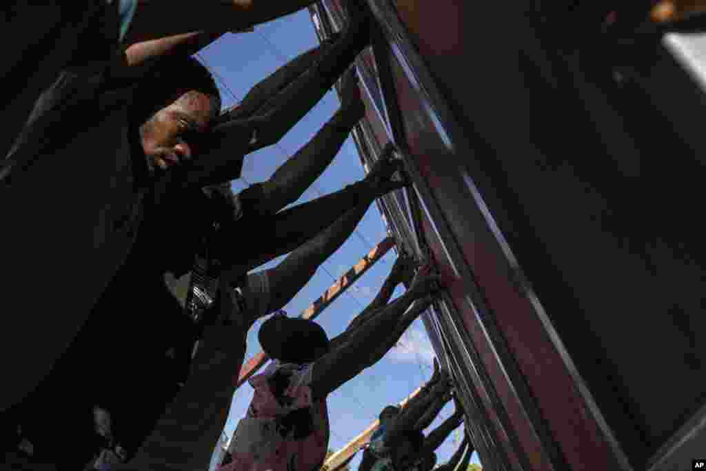 Neighbors install a metal gate as a barricade against gangs,= in the Petion-Ville neighborhood of Port-au-Prince, Haiti, April 20, 2024.
