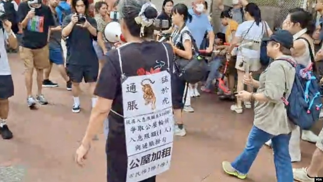 香港社運人士雷玉蓮7月1日,獨自一人由銅鑼灣崇光百貨遊行到政府總部抗議公屋加租。(美國之音照片)