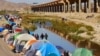 Migrantes venezolanos que buscan asilo cruzan el río Bravo para entregarse a los agentes de la Patrulla Fronteriza de Estados Unidos para solicitar asilo en El Paso, Texas, cerca de un campamento para migrantes, visto desde Ciudad Juárez, México, el 17 de noviembre de 2022.