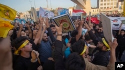 Iraqis raise copies of the Quran during a protest on Tahrir Square, Baghdad, on July 20, 2023, in response to the burning of a Quran in Sweden. (Adil AL-Khazali/AP)