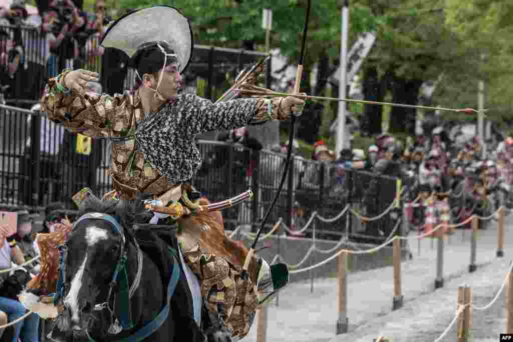 An archer in ancient samurai warrior uniform riding on a horse shoots an arrow to a target during a Yabusame horseback archery demonstration of the samurai martial arts at Sumida Park in Tokyo, April 20, 2024. 