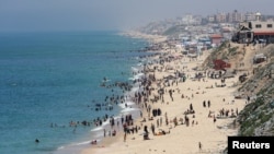 Palestinians enjoy the beach on a hot day amid the ongoing conflict between Israel and Hamas in Deir Al-Balah, in the central Gaza on April 17, 2024. (Ramadan Abed/Reuters)