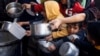 FILE - Palestinian children wait to receive food cooked by a charity kitchen amid shortages of food supplies in Rafah, in the southern Gaza Strip, March 5, 2024. 