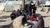 A Palestinian woman bakes bread as children sit next to her, while Gaza residents face crisis levels of hunger and soaring malnutrition, in Khan Younis in the southern Gaza Strip, Jan. 24, 2024.