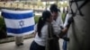 Miembros de la comunidad israelí en Colombia borran graffiti anntisemita en la pared de la embajada de Israel en Bogotá el 9 de octubre de 2023.
