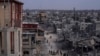 FILE - Palestinians walk through the destruction in the wake of an Israeli air and ground offensive in Khan Younis, southern Gaza Strip, April 8, 2024. 