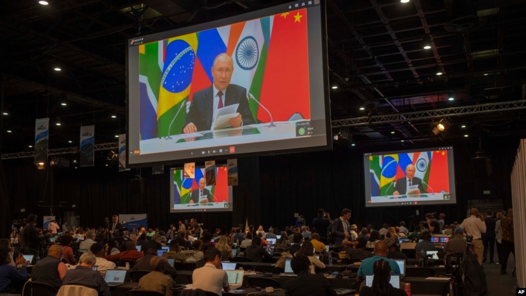 Members of the media watch Russia's President Vladimir Putin address, via videolink, the 2023 BRICS Summit in Johannesburg, South Africa, Aug. 23, 2023.