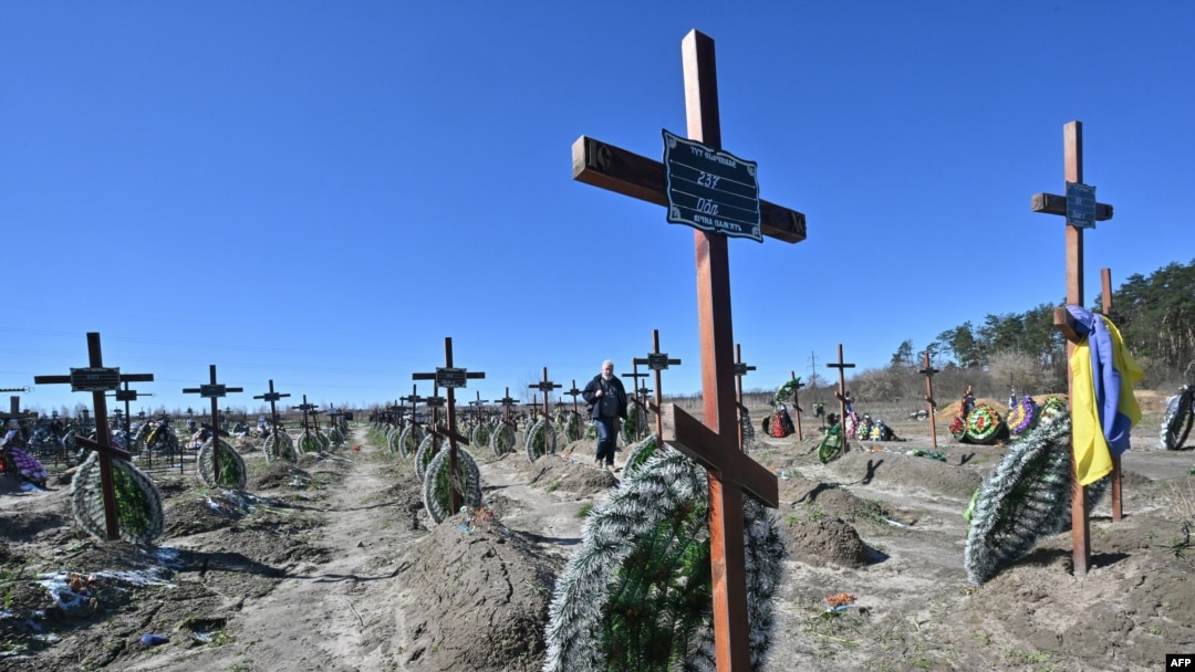 Un hombre camina entre las tumbas de personas locales no identificadas que fueron asesinadas en la ciudad ucraniana de Bucha, al noroeste de Kiev, un día antes de la celebración del primer aniversario de la liberación de Bucha de las tropas rusas el 31 de marzo.