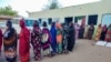 FILE - Internally displaced women wait to collect aid from a group at a camp in Gadaref on May 12, 2024, while clashes reignited between the Sudanese army and rival paramilitaries in the key Darfur town of El Fasher.