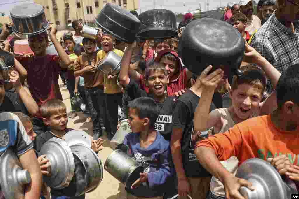 Displaced Palestinian children line up to receive food in Rafah, on the southern Gaza Strip.