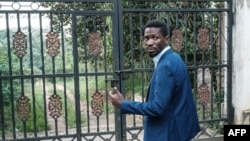 Kiongozi wa upinzani wa Uganda Robert Kyagulanyi, anayejulikana kama Bobi Wine akiwa katika lango la nyumba yake huko Magere, Uganda Januari 15, 2021. Picha na Yasuyoshi CHIBA / AFP.