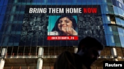 ARCHIVO - Un hombre pasa por un edificio con fotos de rehenes secuestrados en el ataque mortal del 7 de octubre contra Israel por parte del grupo islamista palestino Hamas desde Gaza, en Tel Aviv, el 25 de marzo de 2024.