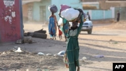 People flee their neighborhoods amid fighting between the army and paramilitaries in Khartoum on April 19, 2023. (AFP)