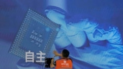 一名工人在上海舉辦的世界人工智能大會上檢視中國科技公司中科曙光展示的芯片和自主字樣的螢幕。 （2023年7月5日）