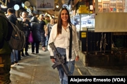Una joven recluta pasea con su arma reglamentaria por el mercado Mehané Yehudá, en Jerusalén.