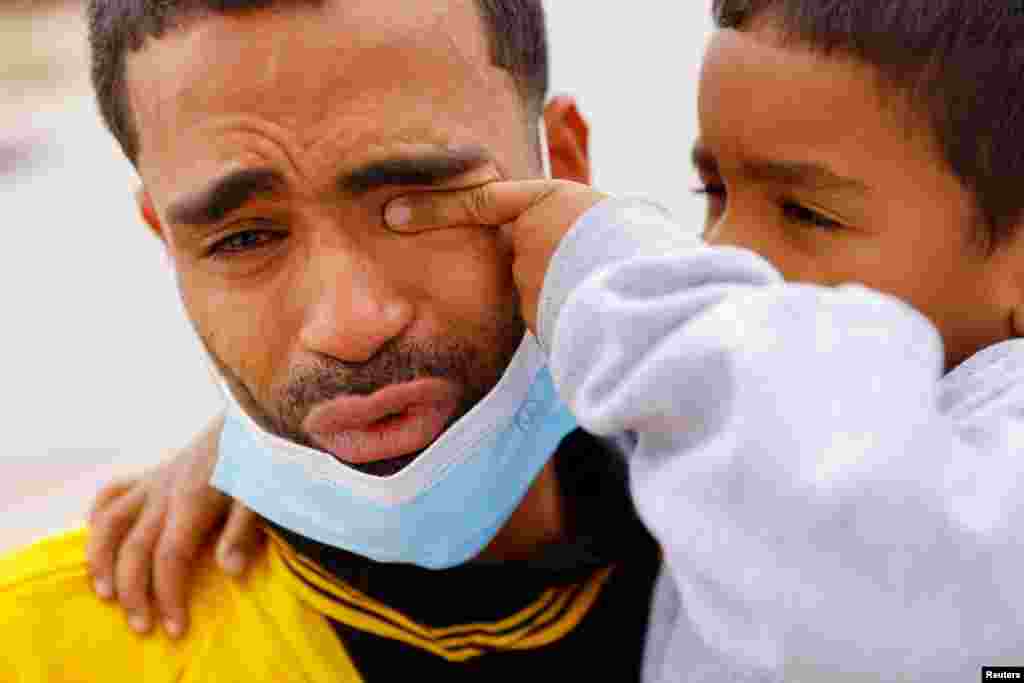 Saul, 4, wipes the tears of his father Franklin Pajaro, after they were expelled from the U.S. and sent back to Mexico under Title 42, near the Paso del Norte International border bridge, in Ciudad Juarez, Mexico, Oct. 17, 2022.