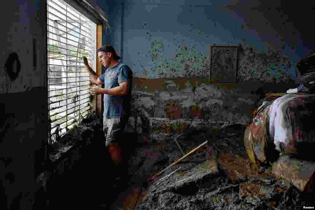 Juan Figalo looks out of the window of what was left of his bedroom in the aftermath of devastating floods following heavy rain, in the neighborhood of El Castano, in Maracay, Aragua state, Venezuela, Oct. 18, 2022.
