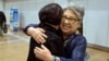 Sandra Suh (r) hugs an unidentified woman at the arrival gate of the Beijing Capital International Airport, April 9, 2015.
