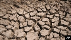 Se observa lodo seco agrietado en un embalse comunitario que quedó casi vacío después de que su muro de contención comenzó a gotear y el clima cálido y las condiciones de sequía aceleraron la pérdida de agua en la aldea de Longquan en el municipio de Chongqing, suroeste de China, el 20 de agosto de 2022.