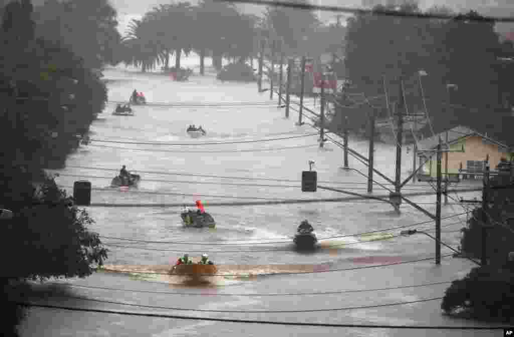 People use small boats to travel through flood water in Lismore, Australia, Feb. 28, 2022. Heavy rain is bringing record flooding to some east coast areas and claimed seven lives while the flooding in Brisbane, a population of 2.6 million, and its surrounds is the worst since 2011.