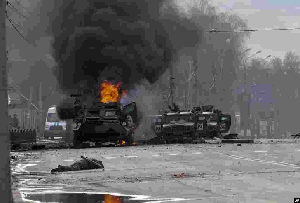 A Russian armored personnel carrier burns amid damaged and abandoned light utility vehicles after fighting in Kharkiv, Ukraine, Feb. 27, 2022. 