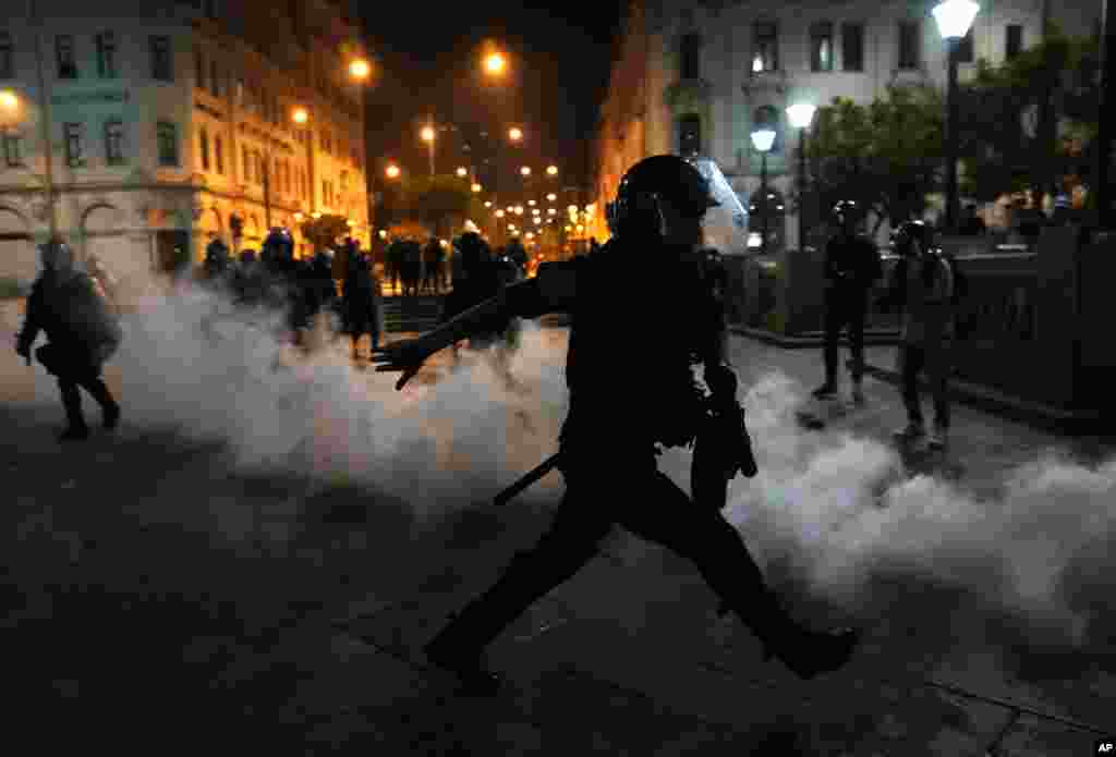 Tear gas is returned to police trying to break up supporters of ousted President Pedro Castillo at plaza San Martin in Lima, Peru, Dec. 11, 2022. Peru's Congress voted to remove Castillo from office and replace him with the vice president, shortly after Castillo tried to dissolve the legislature ahead of a scheduled vote to remove him.