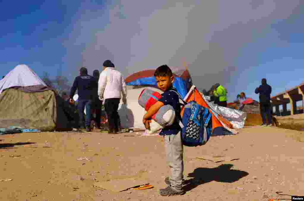 A child stands as police remove Venezuelan migrants from a camp on the banks of the Rio Bravo river, in Ciudad Juarez, Mexico, Nov. 27, 2022.