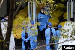 上海一家火葬場的工作人員走過數個逝者的屍袋。（2023年1月4日）
