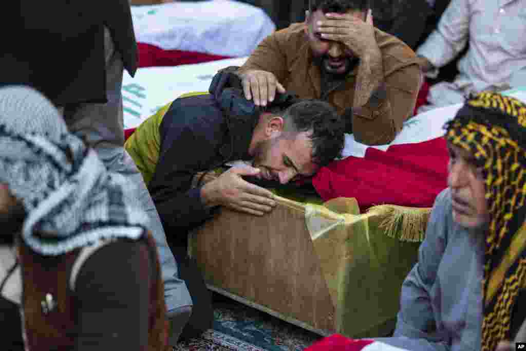 People mourn over the coffins of people killed in a militant attack during their funeral in Najaf, Iraq. Eight people were killed in the attack by gunmen on motorbikes, officials said.