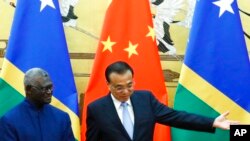 FILE - Solomon Islands Prime Minister Manasseh Sogavare, left, and Chinese Premier Li Keqiang attend a signing ceremony at the Great Hall of the People in Beijing, Oct. 9, 2019.