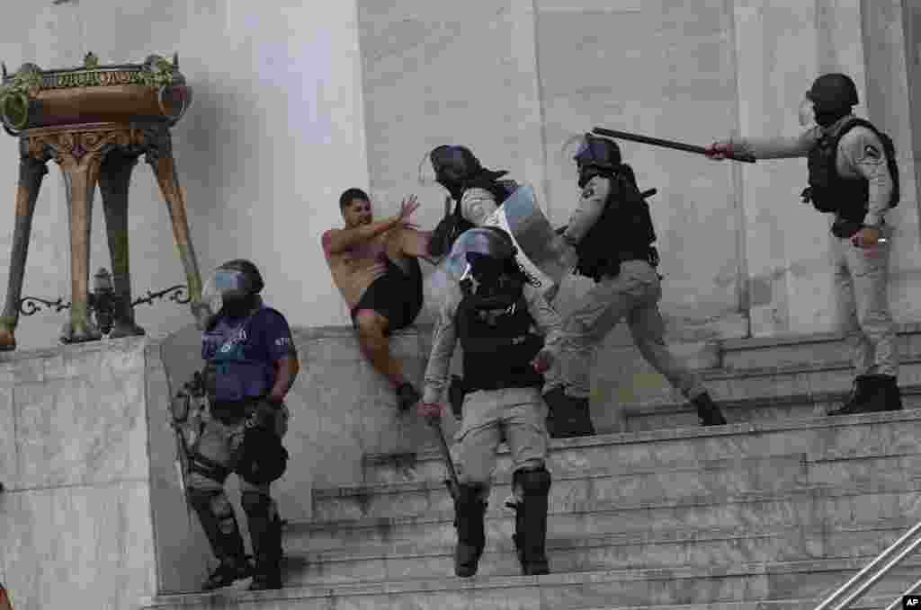 A Flamengo soccer fan is cornered by police during clashes as Flamengo celebrates their Copa Libertadores 2022 title, in Rio de Janeiro, Brazil.