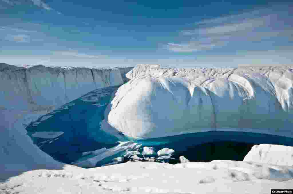 For several summers this deeply incised melt channel transported overflow from a large melt lake to a Moulin, a conduit that drains the water through many hundreds of feet to the ice sheet’s bed. (Photo courtesy Ian Joughin)