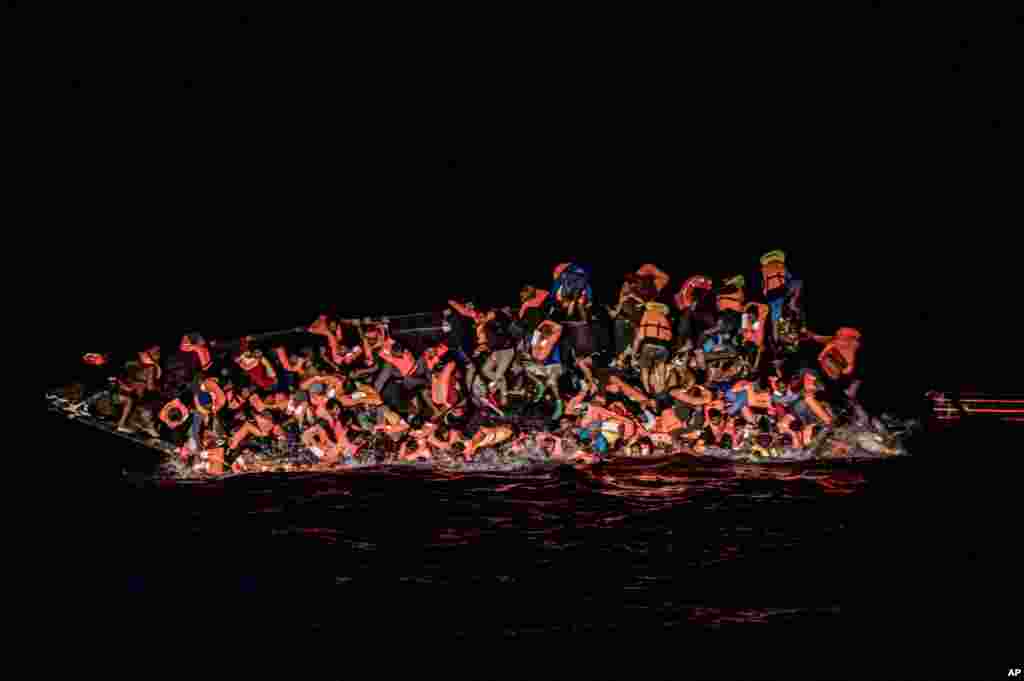 Dozens of migrants fall in the water while they struggle to cling to the side of an upturning boat off the waters of Tunisia, May 25, 2022.