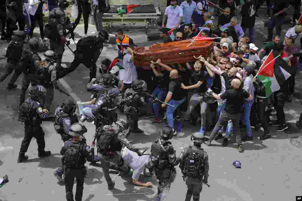 Israeli police confront mourners as they carry the casket of slain Al Jazeera veteran journalist Shireen Abu Akleh during her funeral in east Jerusalem, May 13, 2022. Abu Akleh, a Palestinian-American reporter who covered the Mideast conflict for more than 25 years, was shot dead during an Israeli military raid in the West Bank town of Jenin.
