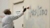 Un hombre pinta sobre un grafiti racista al costado de una mezquita en lo que las autoridades llaman un aparente crimen de odio, en Roseville, California, el 1 de febrero de 2017.