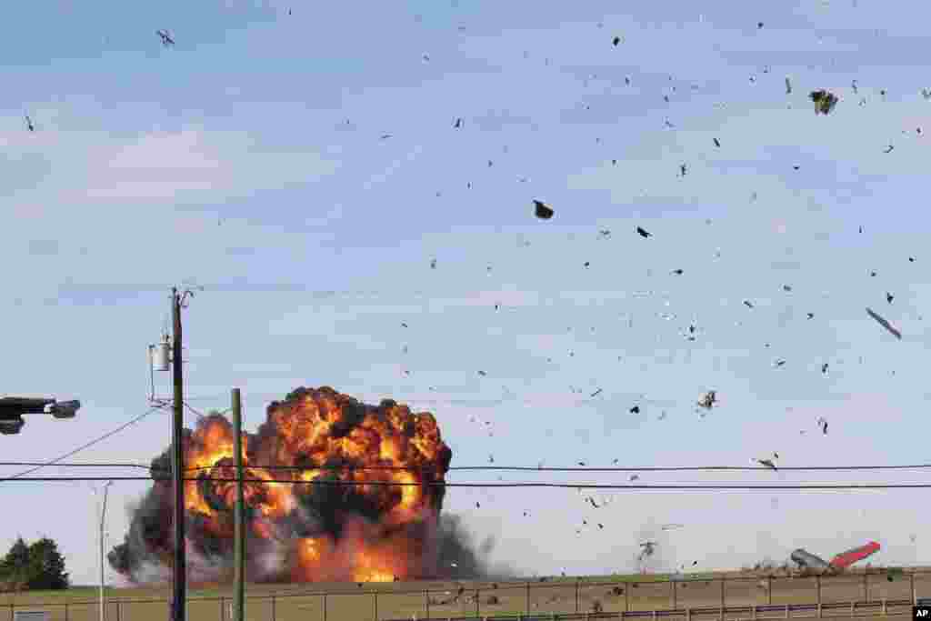 In this photo provided by Nathaniel Ross Photography, a military plane crashes after colliding with another plane during an airshow at Dallas Executive Airport in Dallas, Texas, Nov. 12, 2022.