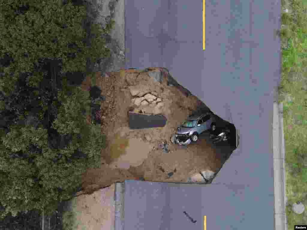 Two vehicles are seen after falling into a sinkhole in Chatsworth, California.