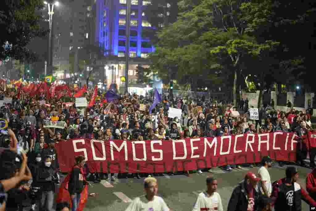 Demonstrators march holding a banner that reads in Portuguese, "We are Democracy," during a protest calling for protection of the nation's democracy in Sao Paulo, Brazil, Jan. 9, 2023, a day after supporters of former President Jair Bolsonaro stormed government buildings in the capital.