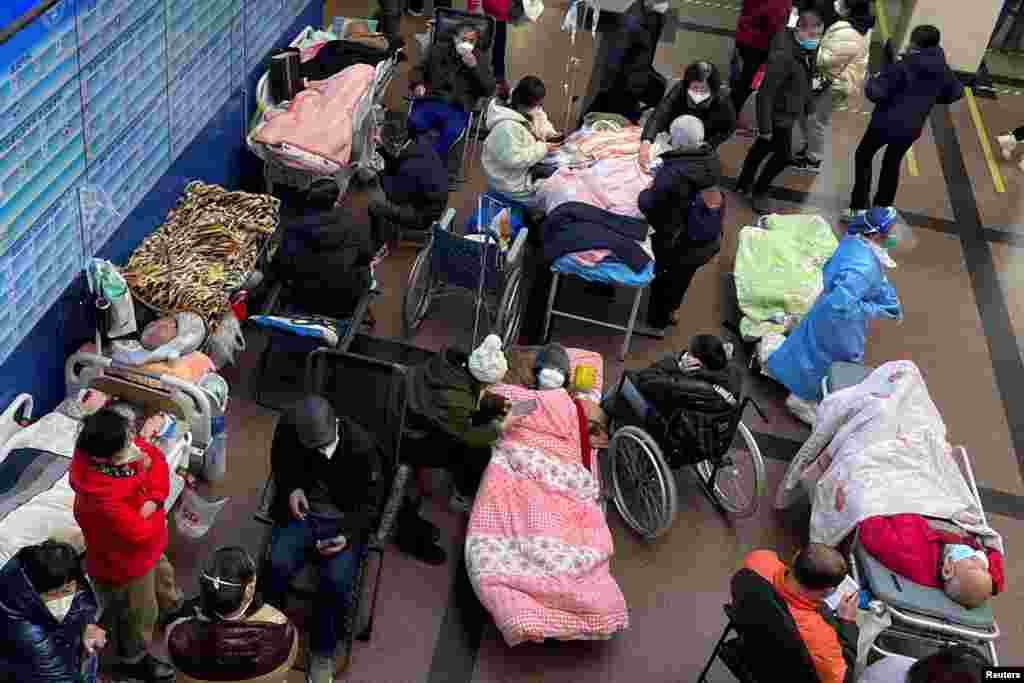 Patients lie on beds and stretchers in a hallway at the emergency department of a hospital, amid a COVID-19 outbreak in Shanghai, China.