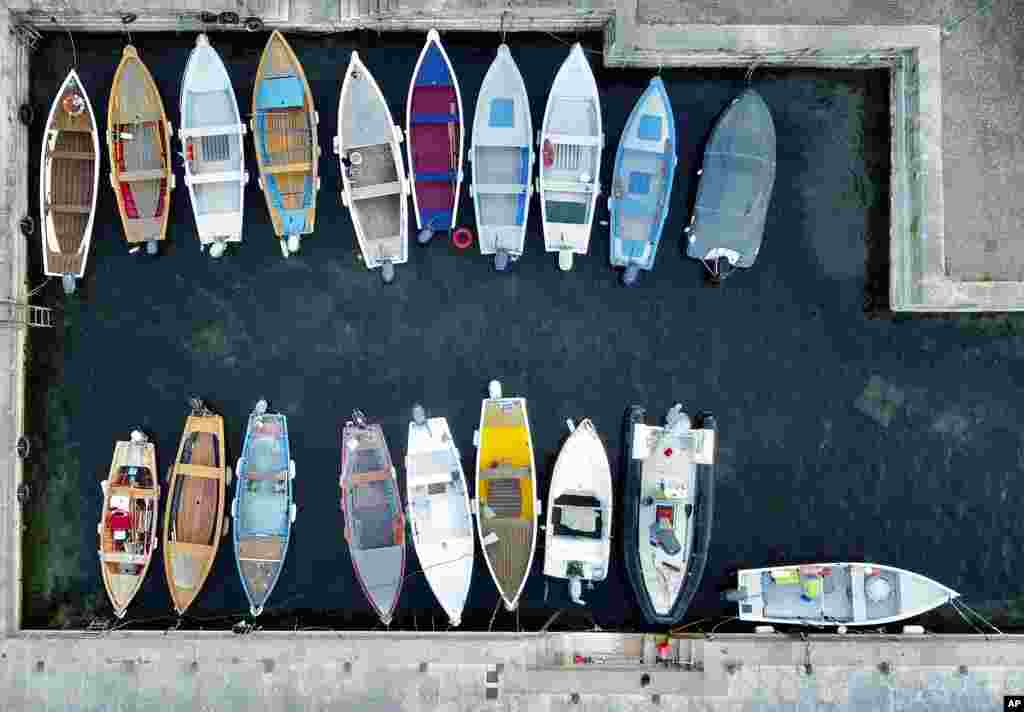 A man cleans his boat in the early morning at Lake Garda in Brenzone sul Garda, Italy.