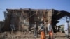 Residents and militias stand next to houses destroyed by an airstrike during fighting between the Ethiopian National Defence Forces (ENDF) and the Tigray People's Liberation Front (TPLF) forces in Kasagita town, Afar region, on February 25, 2022. (Tiksa Negeri/Reuters)