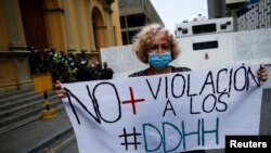 Una persona sostiene un cartel que dice "No más violación de los derechos humanos" en una protesta de maestros, trabajadores de la salud, jubilados y empleados públicos contra el gobierno del presidente de Venezuela, Nicolás Maduro, en Caracas, el 23 de agosto de 2022.