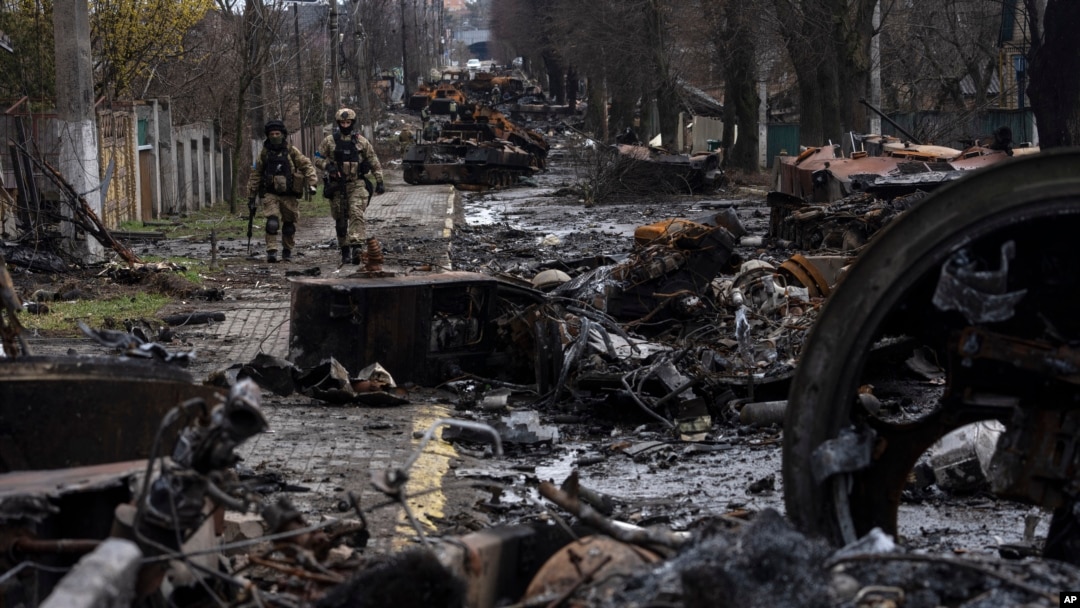 ARCHIVO - Soldados ucranianos caminan entre tanques rusos destruidos en Bucha, en las afueras de Kiev, Ucrania, el 3 de abril de 2022.